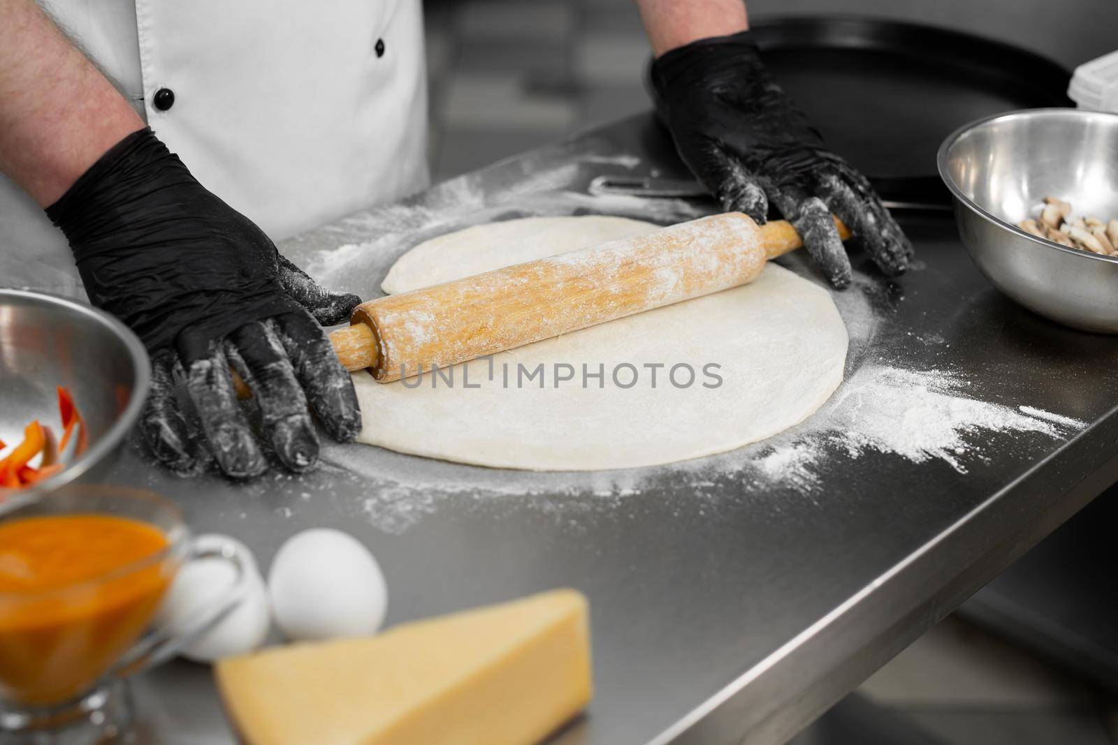 Close up shot of a man rolling dough. Preparation of the dough for pizza. by StudioPeace