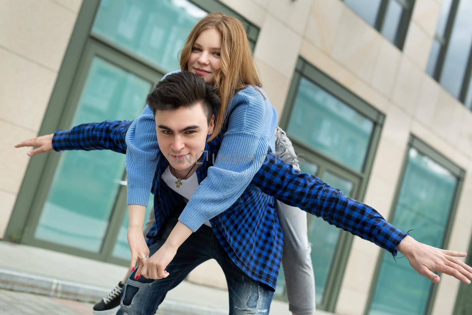 Freedom and fun, emotions and feelings. A cheerful and playful couple is fooling around, gesturing with the wings of an airplane, smiling