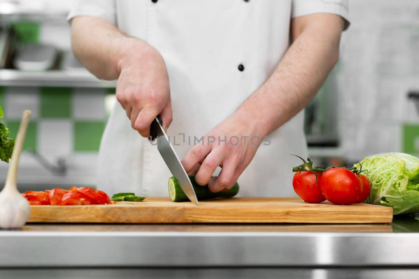 Chef in the kitchen cuts fresh and delicious vegetables for a vegetable salad