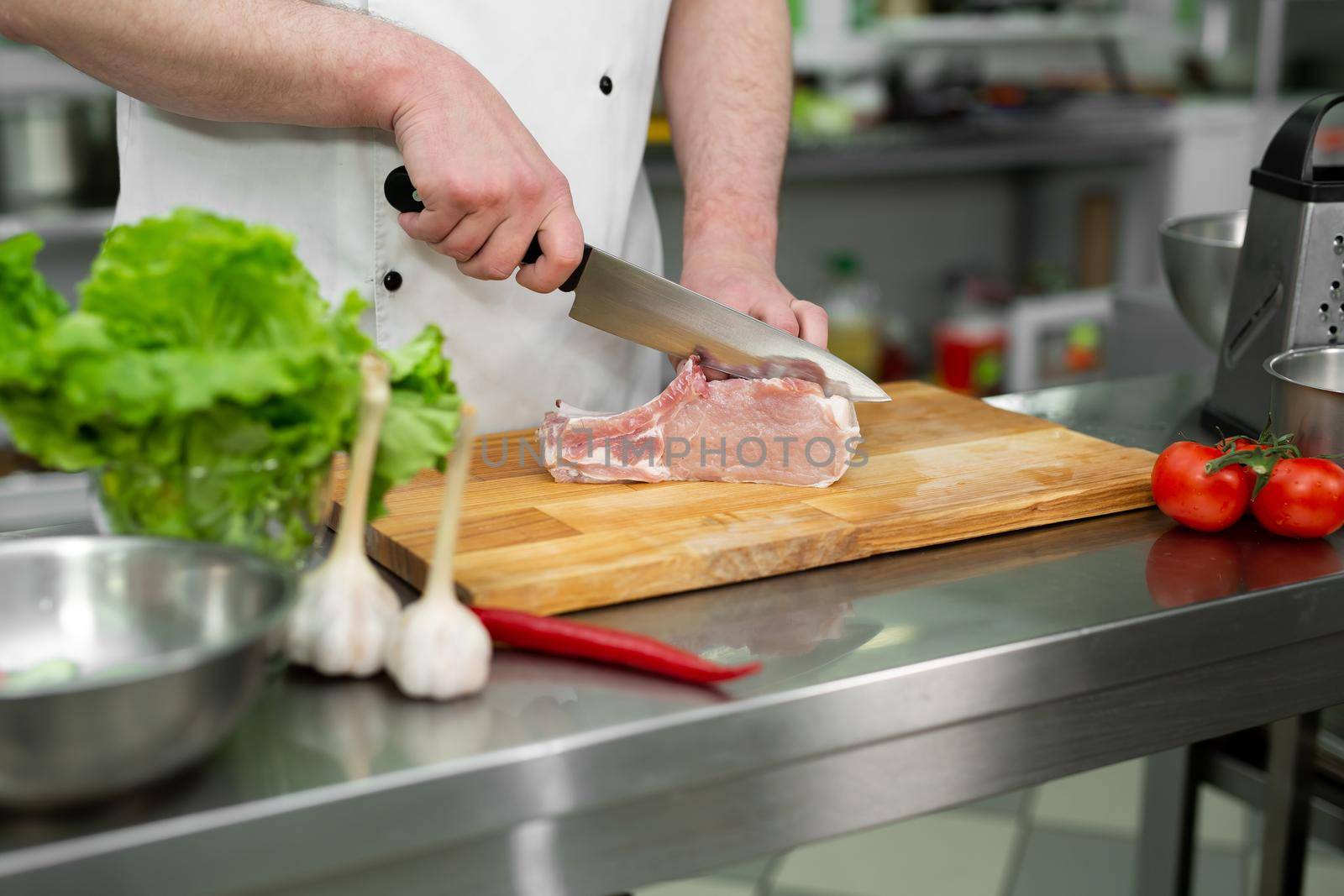 Chef cutting the meat on a wooden board