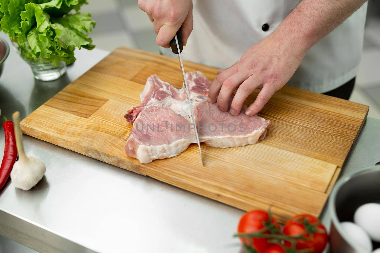 Chef cutting the meat on a wooden board
