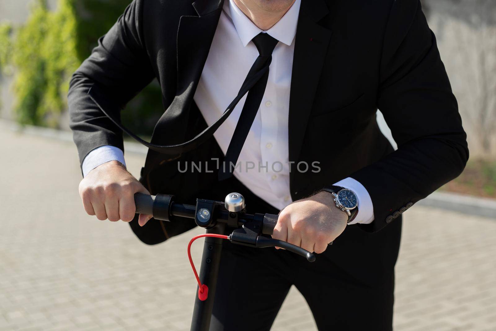 Man in a business suit and sunglasses rides an electric scooter and laughs by StudioPeace