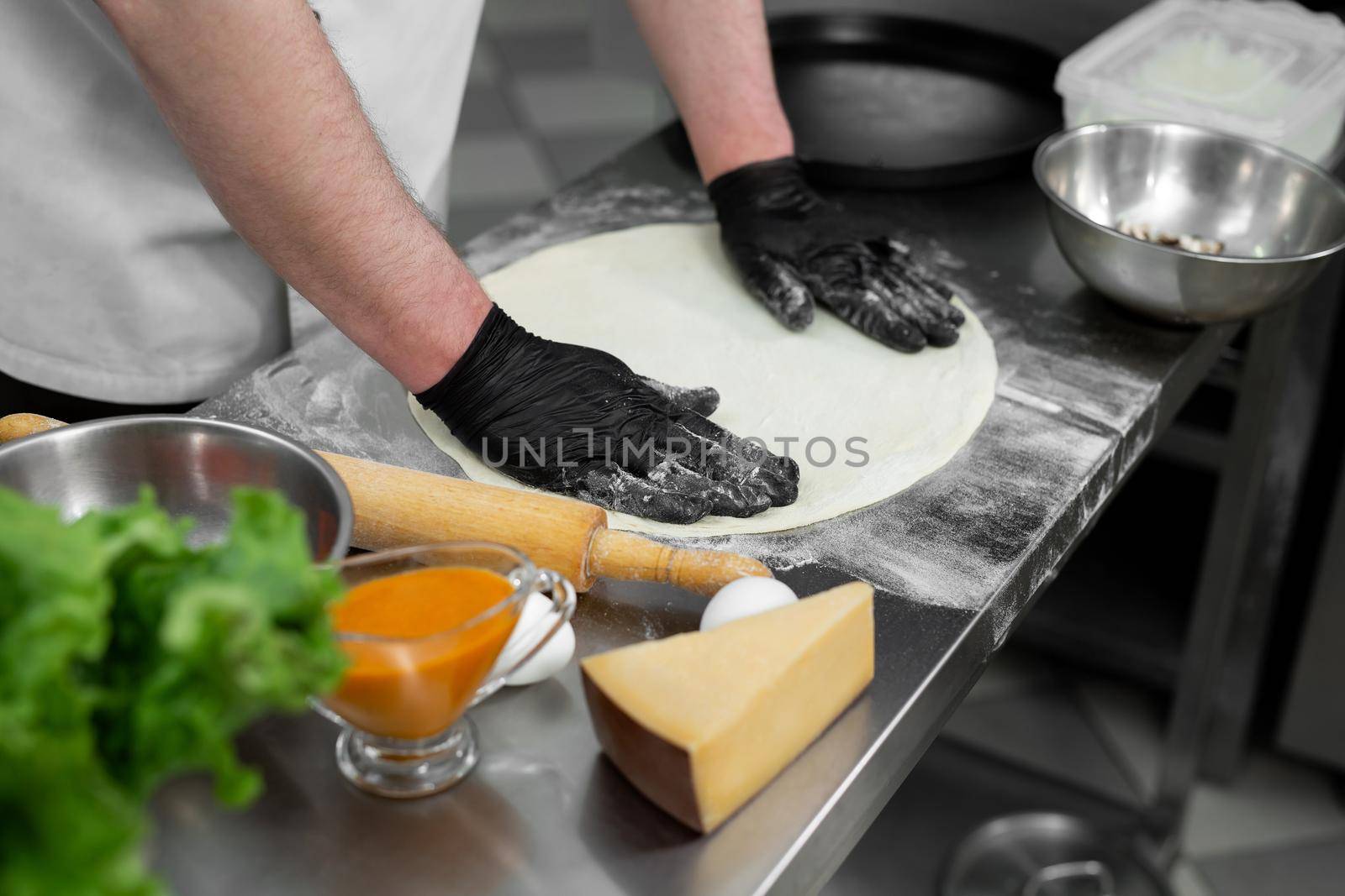 Chef is working in the kitchen with pizza dough