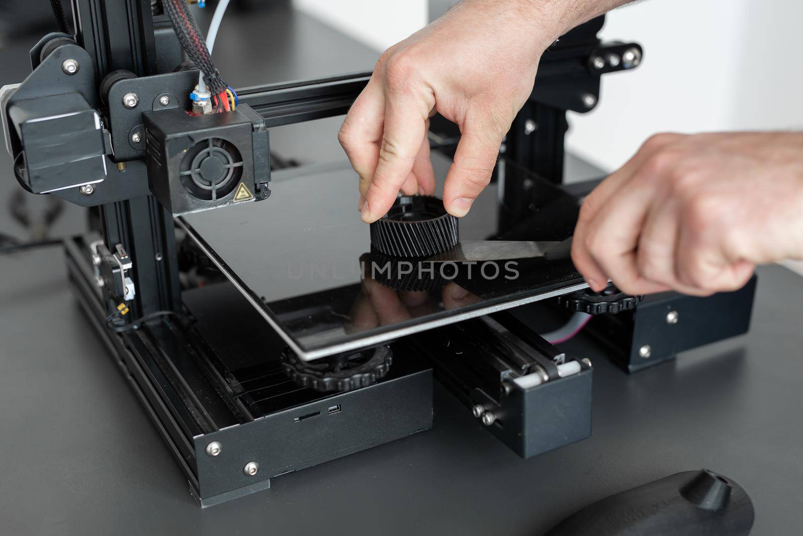 Man removes the finished part from a 3D printer