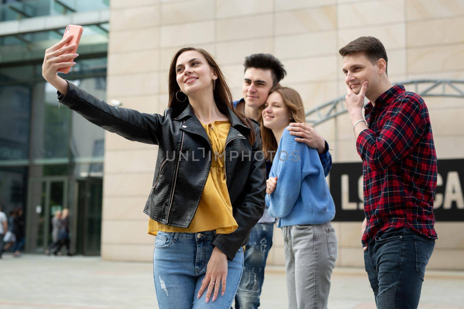 Group of friends taking picture of themselves with smartphone