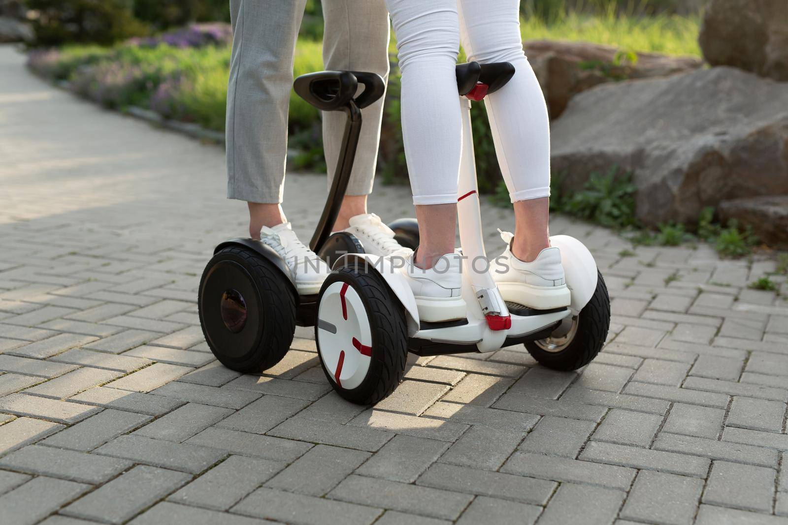 Legs of man and woman riding on the Hoverboard for relaxing time together outdoor at the city