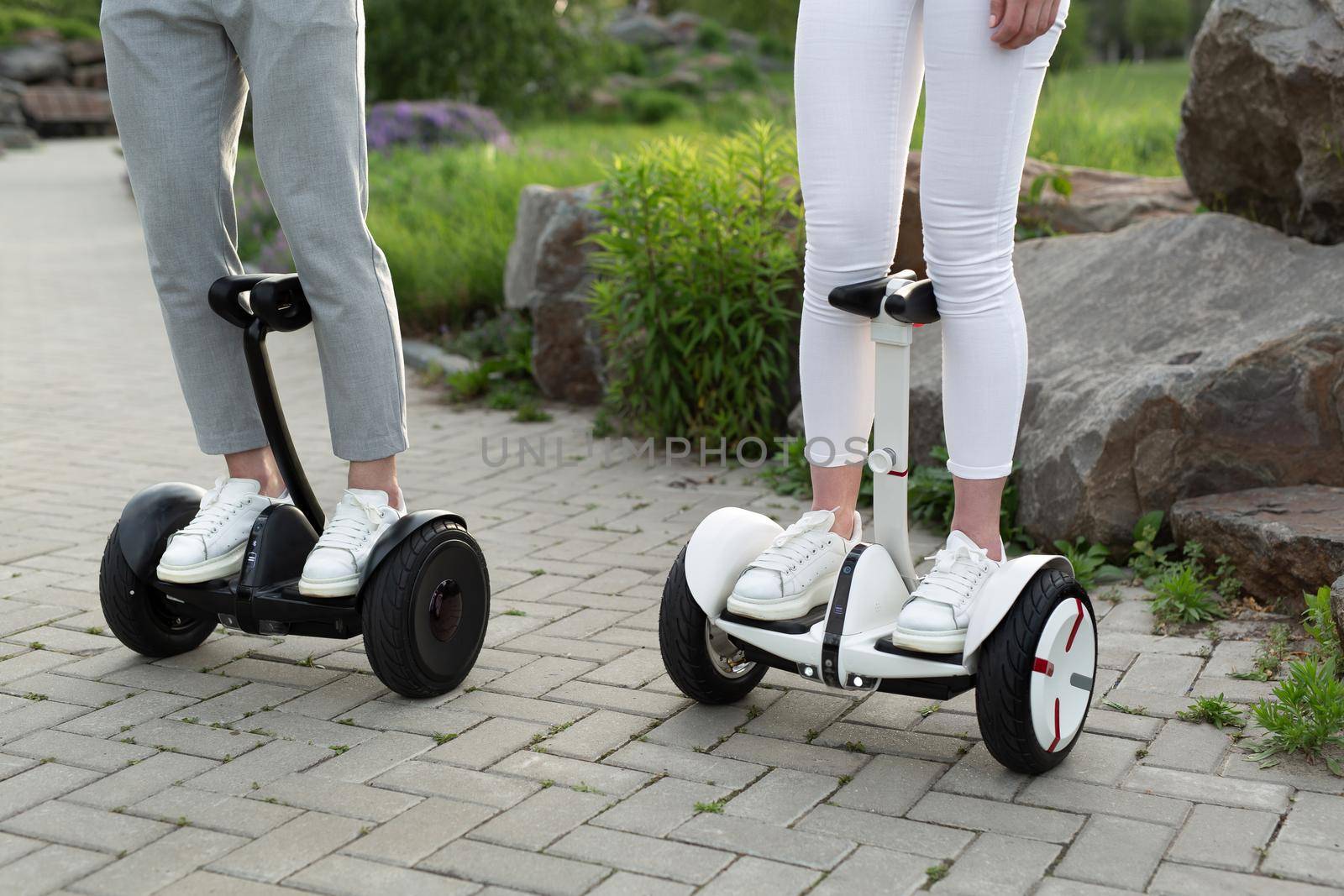 Legs of man and woman riding on the Hoverboard for relaxing time together outdoor at the city