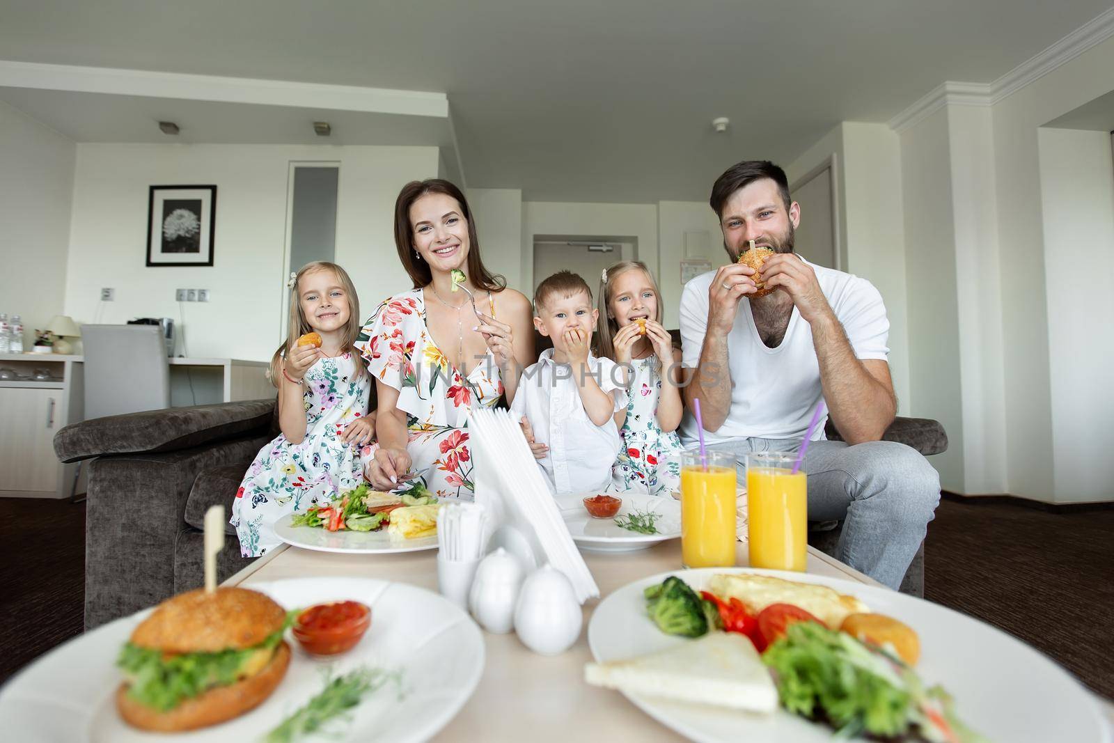 A young family eats breakfast in the hotel room