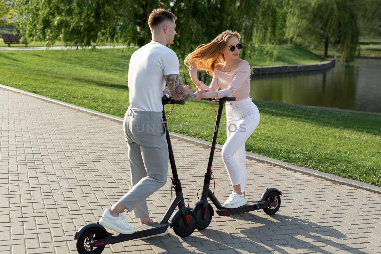 Young couple in the park on electric scooters