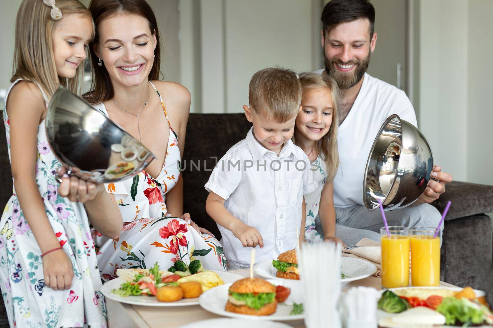 A young family eats breakfast in the hotel room. by StudioPeace