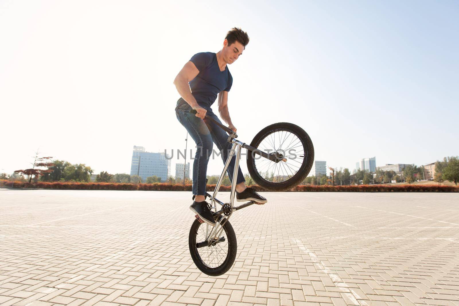Street portrait of a bmx rider in a jump on the street in the background of the city landscape. by StudioPeace