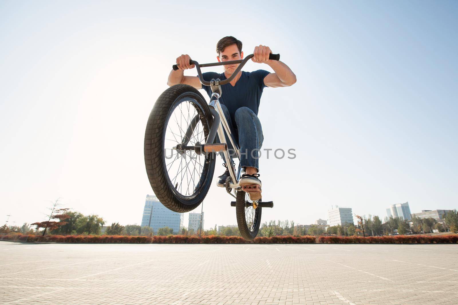 Street portrait of a bmx rider in a jump on the street in the background of the city landscape. by StudioPeace