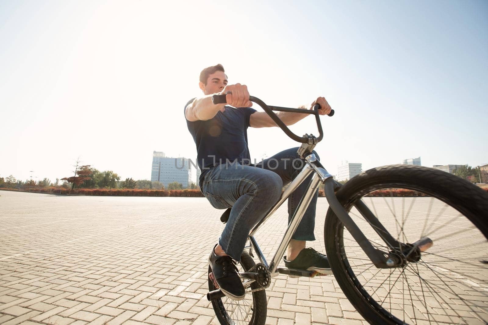 Teenage BMX rider is performing tricks in skatepark. by StudioPeace