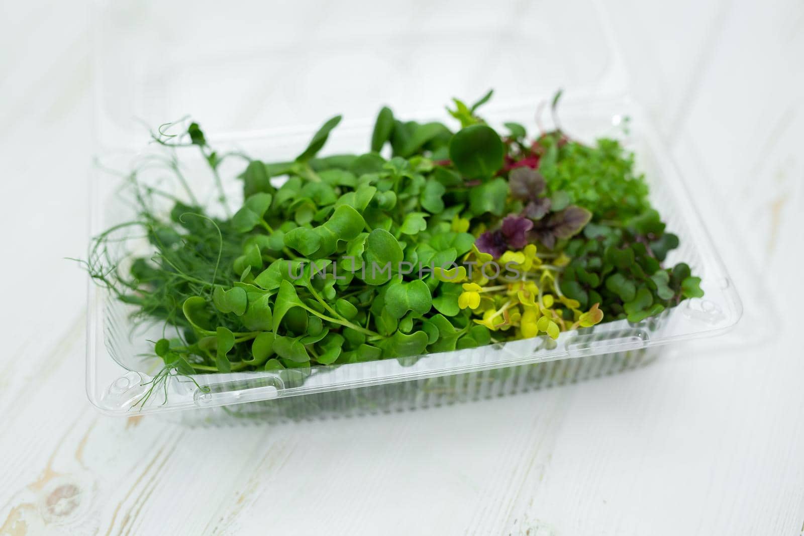 Assorted, a mix of various micro-greens in a transparent plastic box.