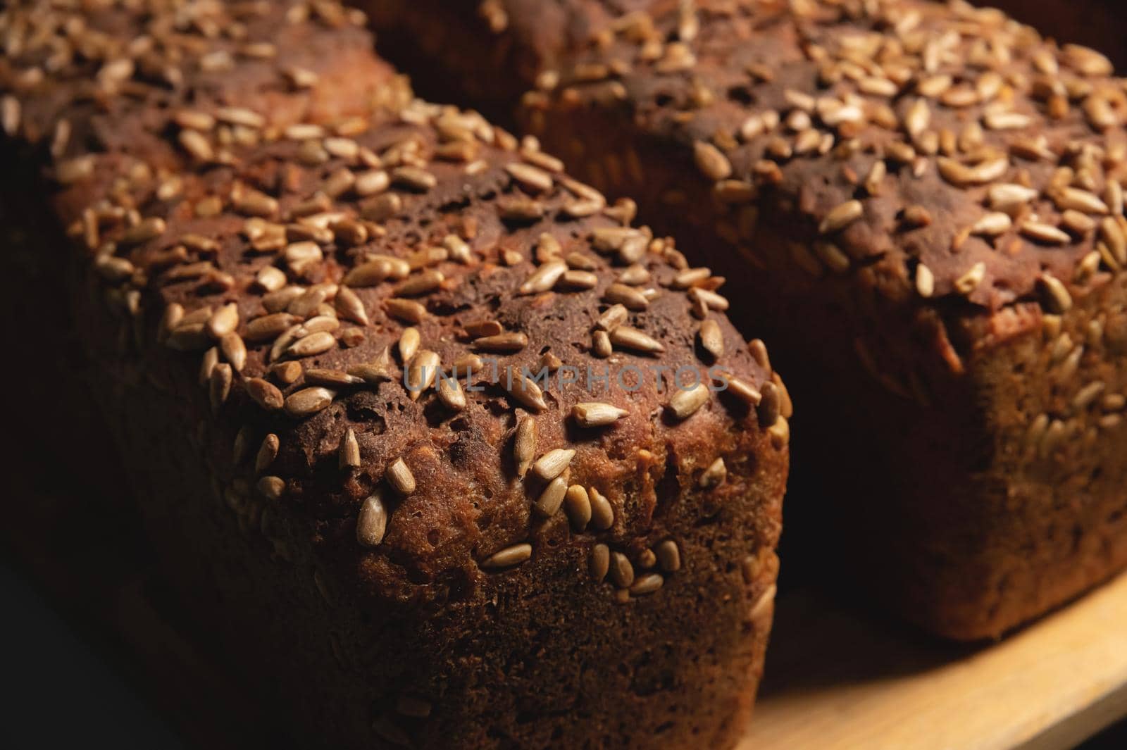 Close-up of rye black bread covered with sunflower seeds. Fresh hot bread. Healthy food. No Yeast.