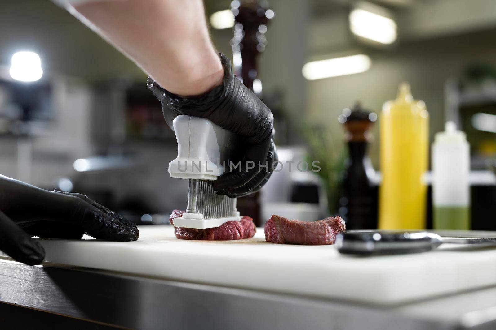 The chef gives the meat the shape of a medallion in the kitchen