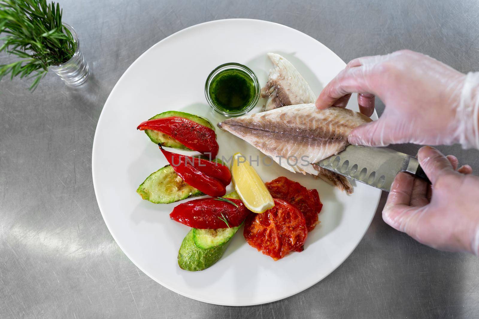 Chef puts the fish on a plate. by StudioPeace