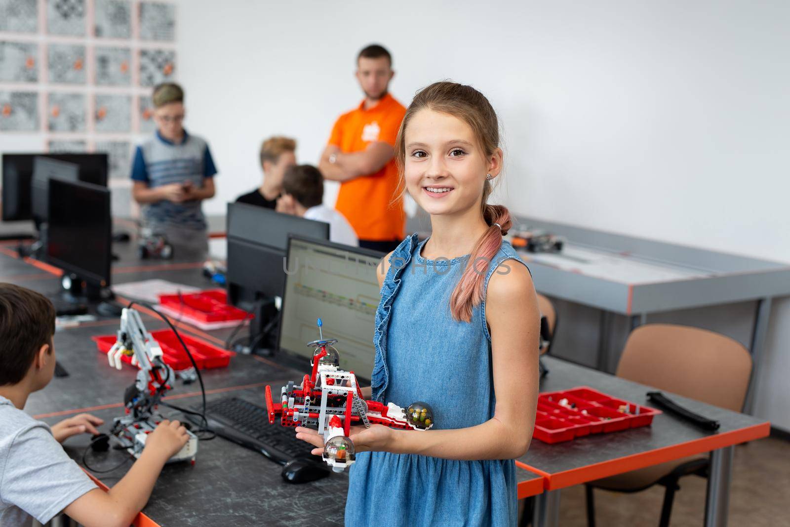 Portrait Of Female Student Building Robot Vehicle In After School Computer Coding Class. by StudioPeace