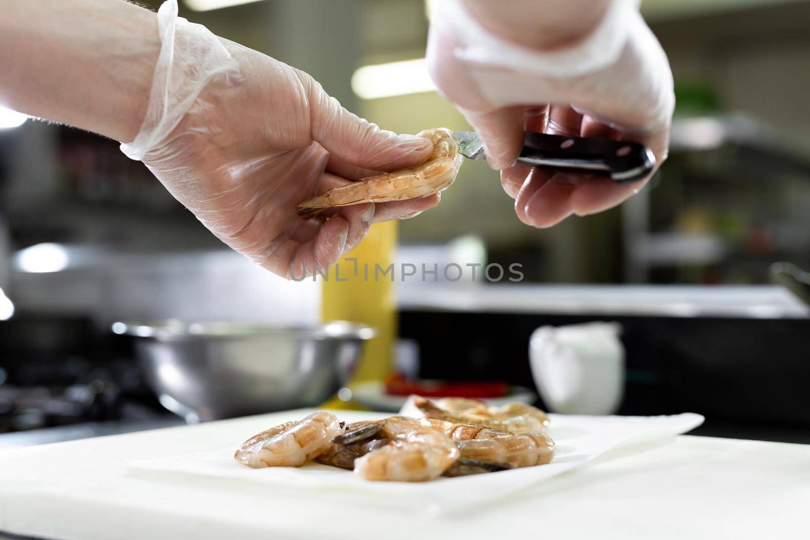 Chef cuts the shrimp. Concept of mediterranean cuisine.