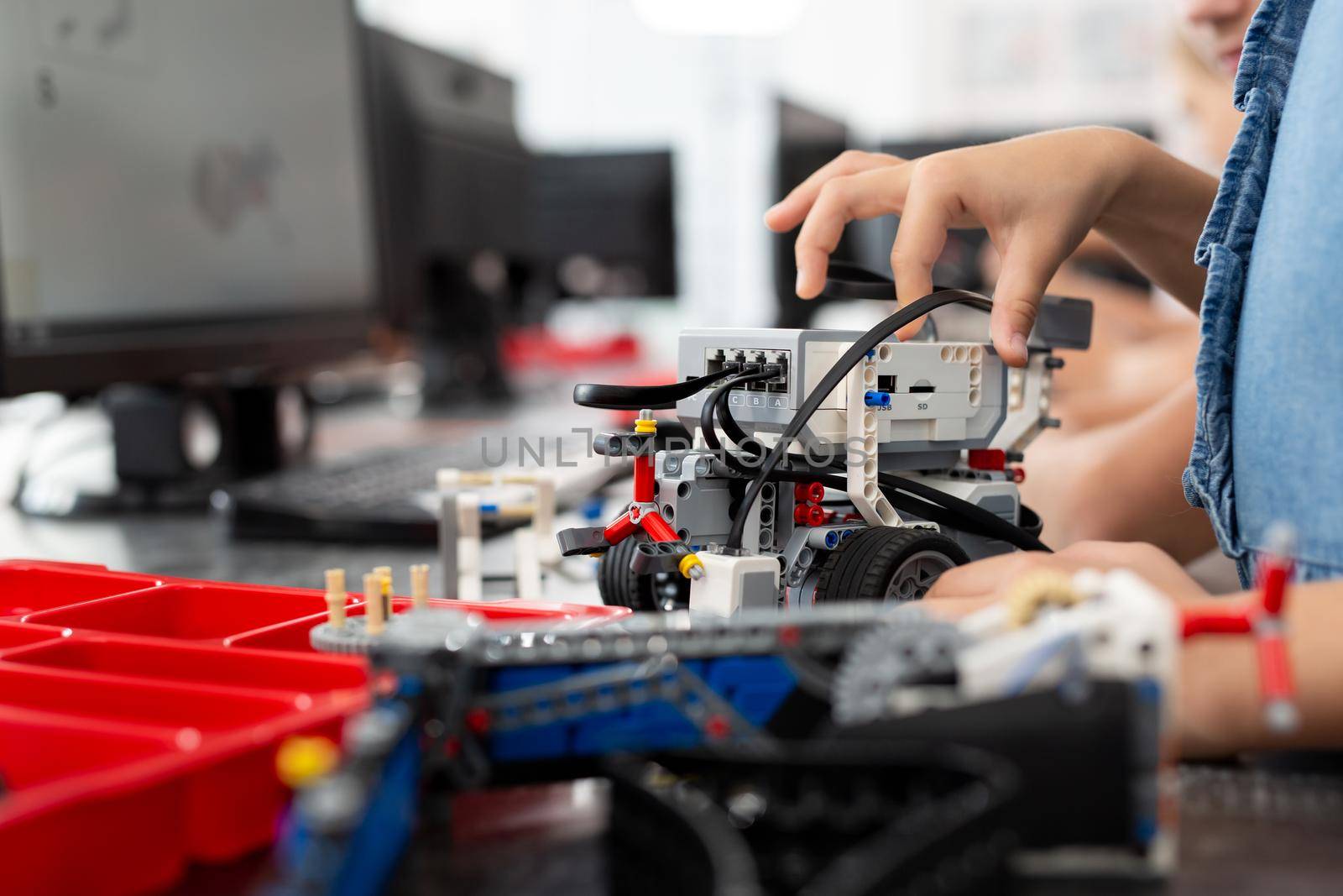 Children play with a robot in a robotics class. by StudioPeace