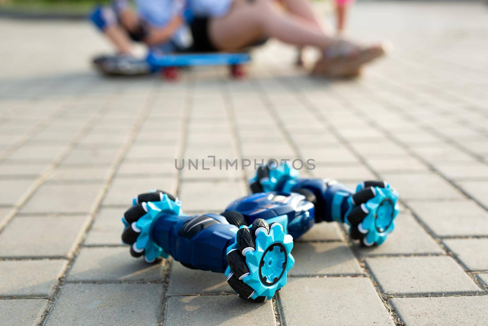 Close-up of a young woman with children playing with a robot car. New technological toys for kids