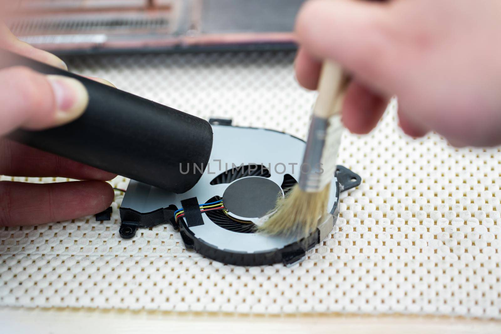 Macro of a brush cleaning a laptop fan