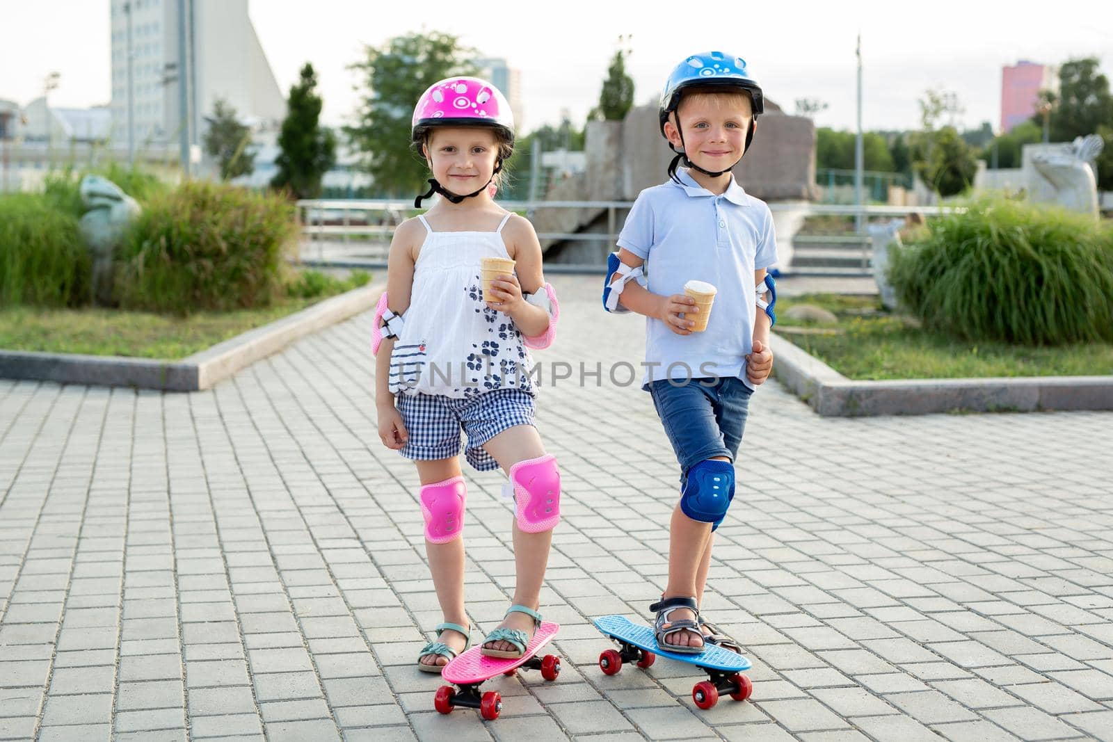 Portrait of children in the park with skates, they eat ice cream