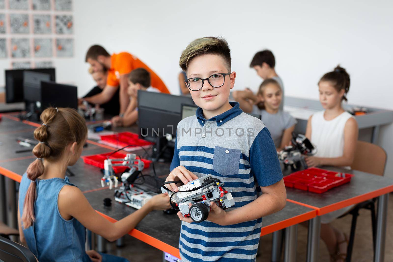 Portrait Of Male Student Building Robot Vehicle In After School Computer Coding Class