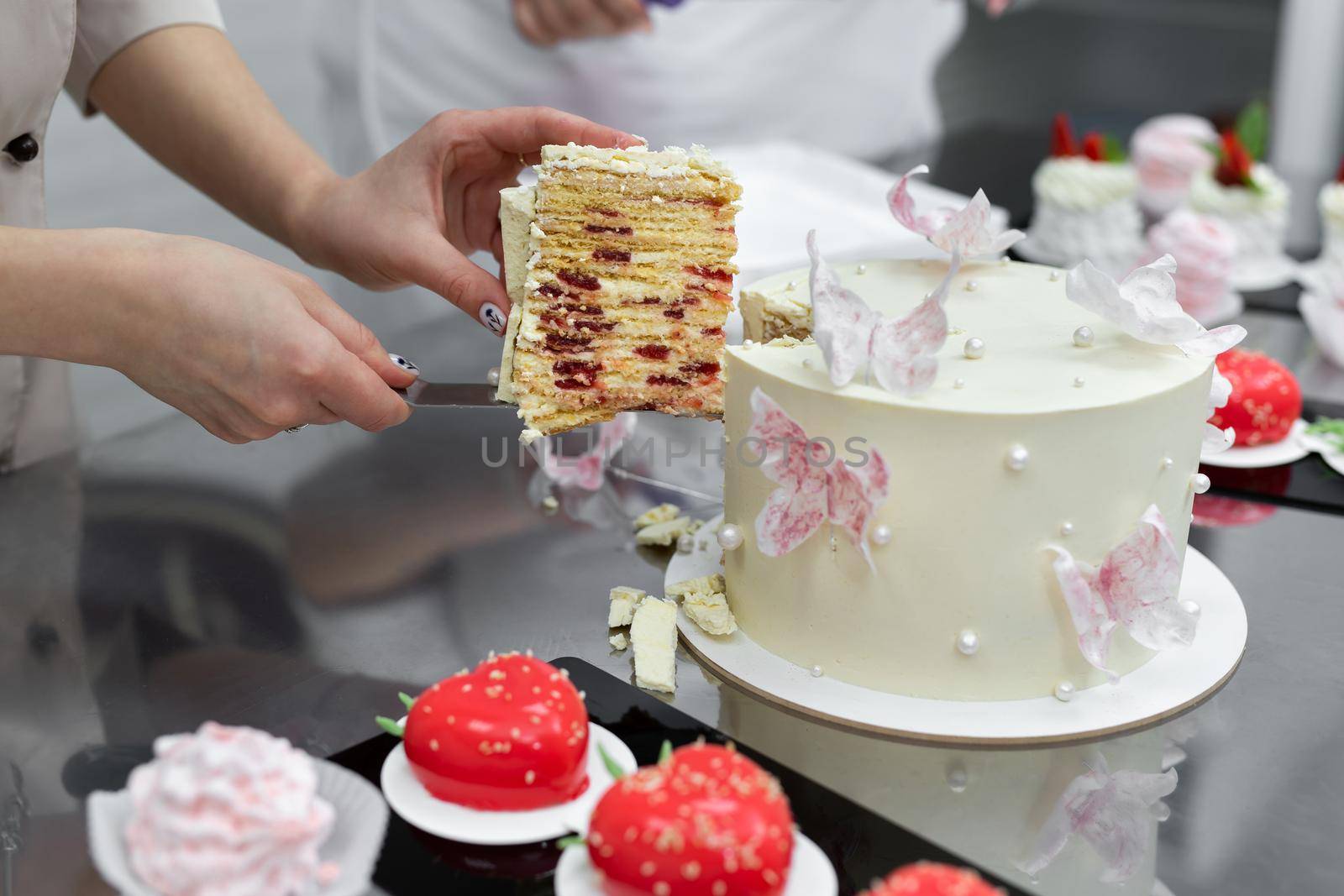 Pastry chef's hands cut the cake with a knife at the master class