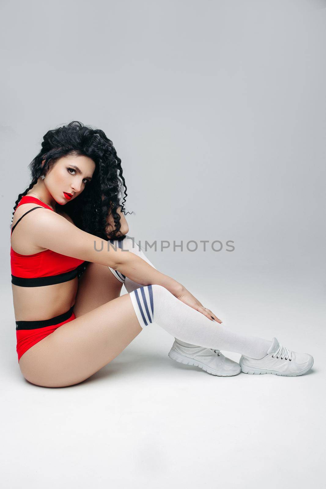 Sexy swag brunette model at white socks posing at studio. by StudioLucky