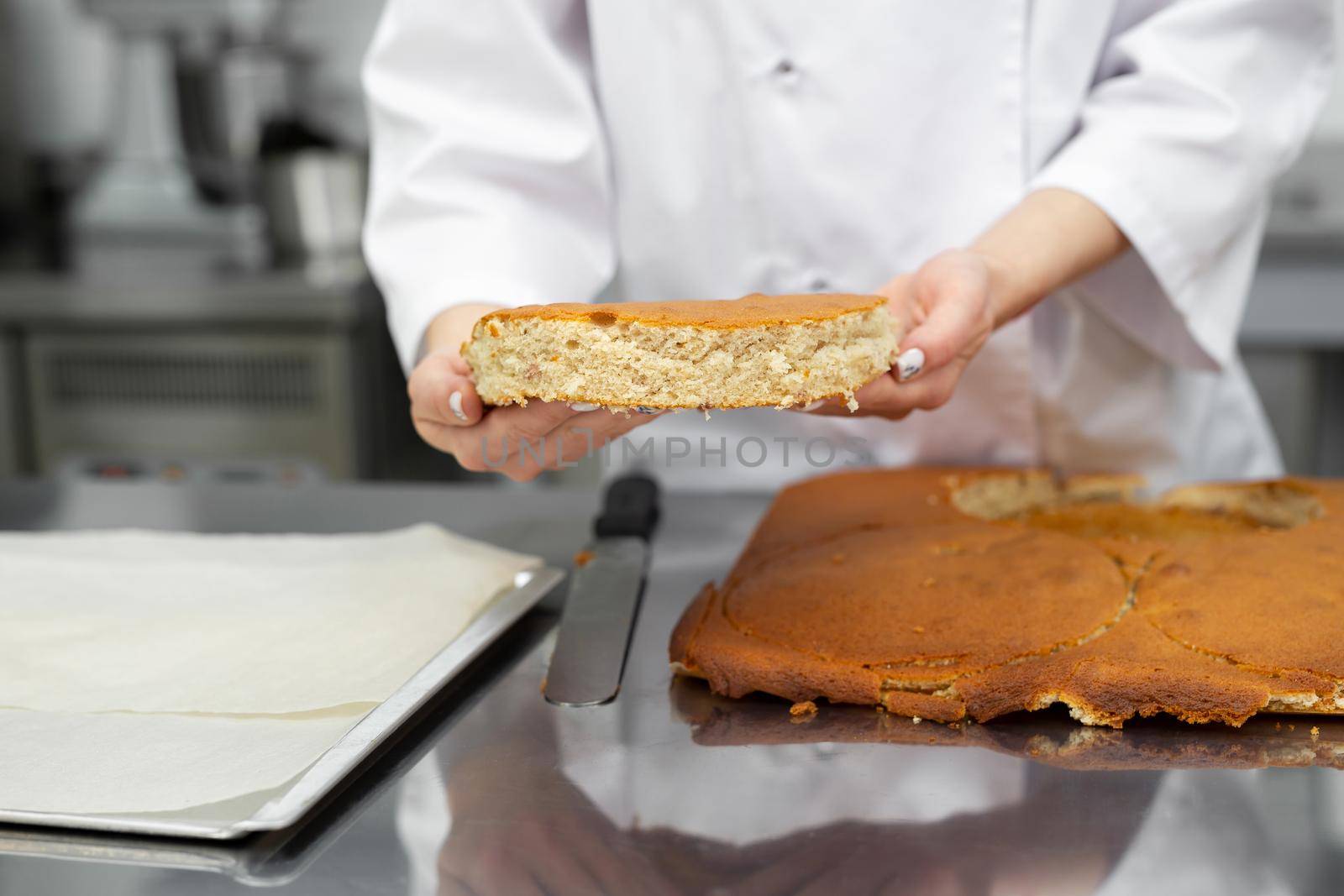 Pastry chef cuts out a cake cake from a biscuit.