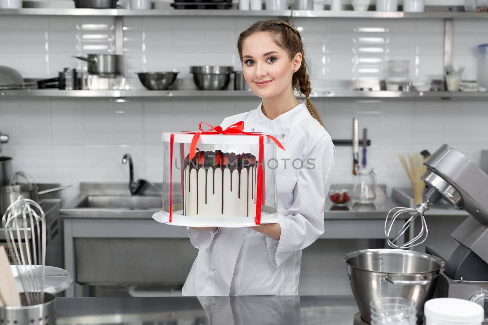 Pastry chef is holding a cake in a package by StudioPeace