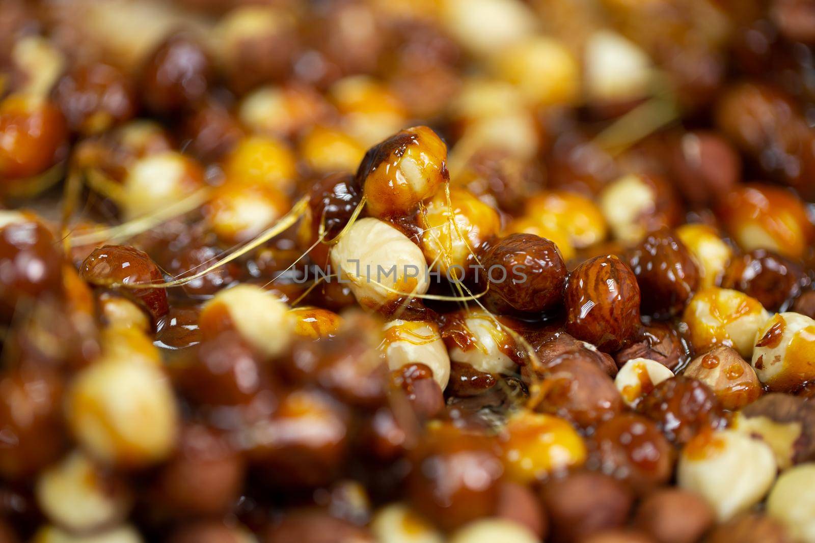 Delicious sweet hazelnut nuts in sugar caramel. Preparation of desserts in a pastry shop from natural ingredients.