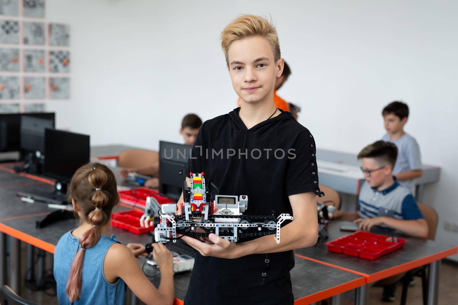 Portrait Of Male Student Building Robot Vehicle In After School Computer Coding Class. by StudioPeace