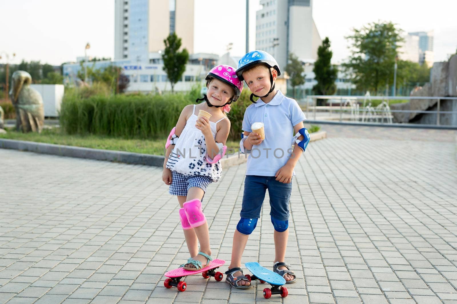 Portrait of children in the park with skates, they eat ice cream