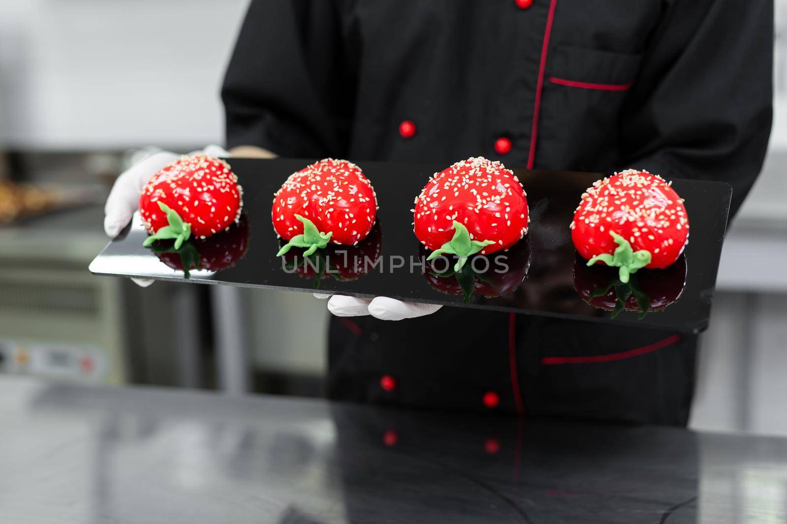 Close-up of mousse cakes in the hands of a pastry chef by StudioPeace
