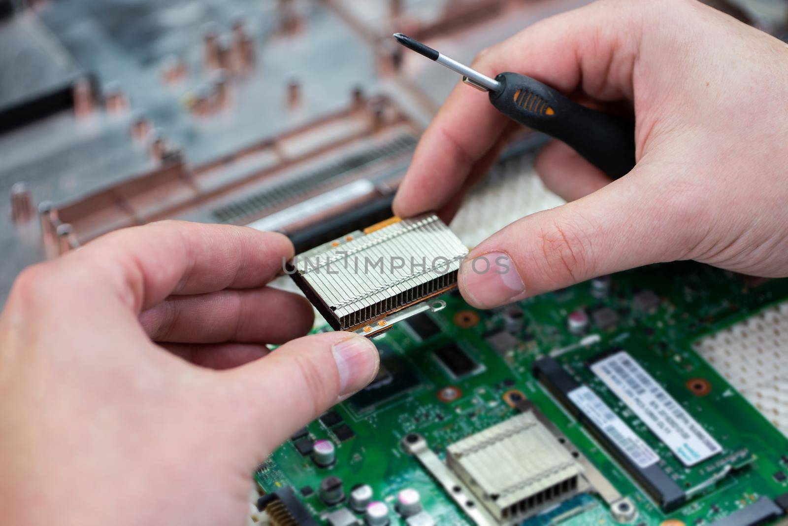 The master repairs the laptop in the service center. by StudioPeace