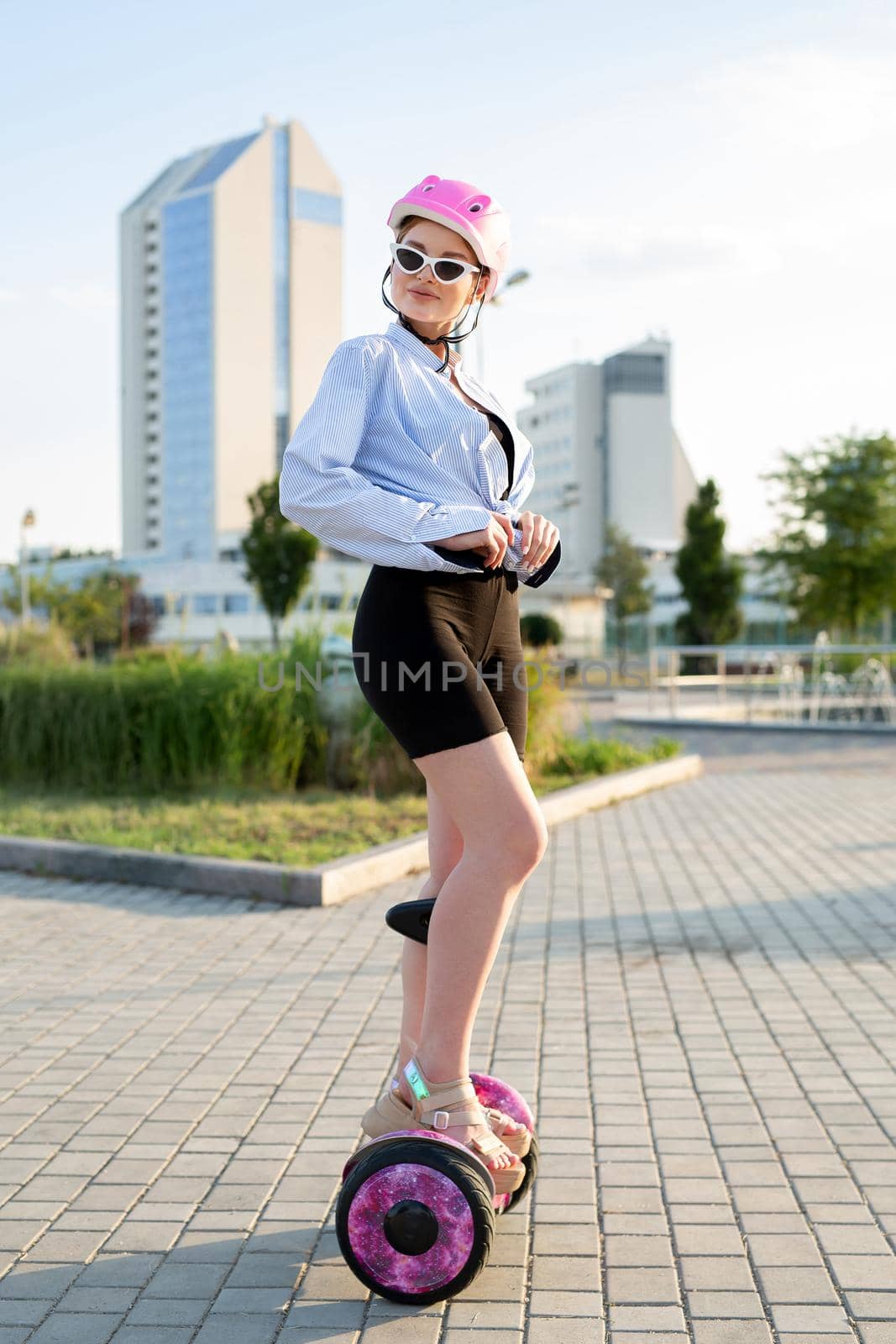 Portrait of a beautiful woman on a hoverboard or gyro scooter in the park. by StudioPeace