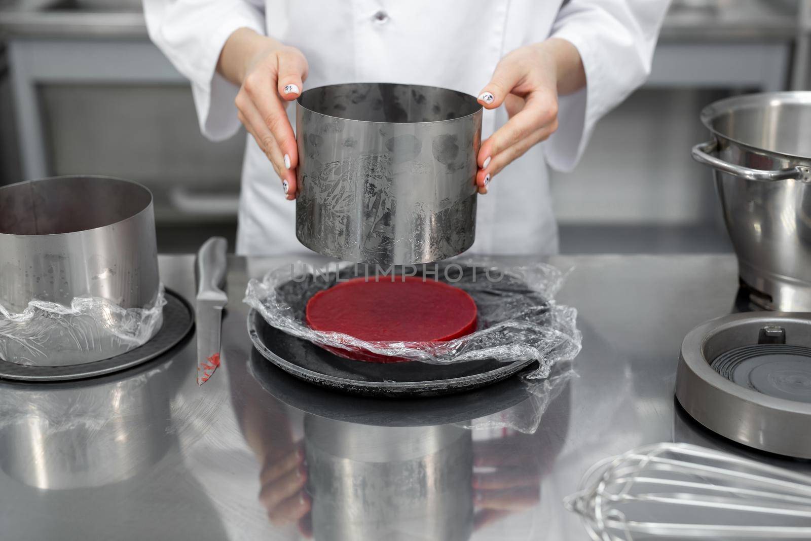 The pastry chef collects the cake. Berry jelly filling for cake. by StudioPeace