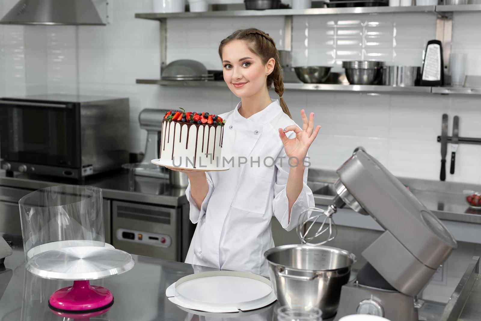 Close-up of a cake in the hands of a pastry chef.