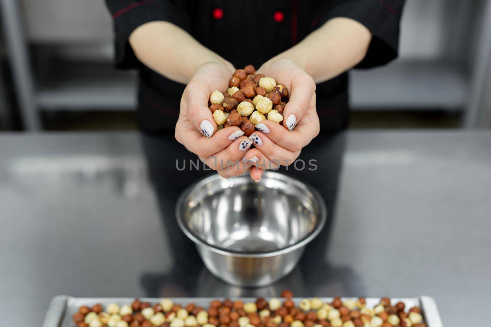 Pastry chef holds a lot of hazelnuts in his hands by StudioPeace