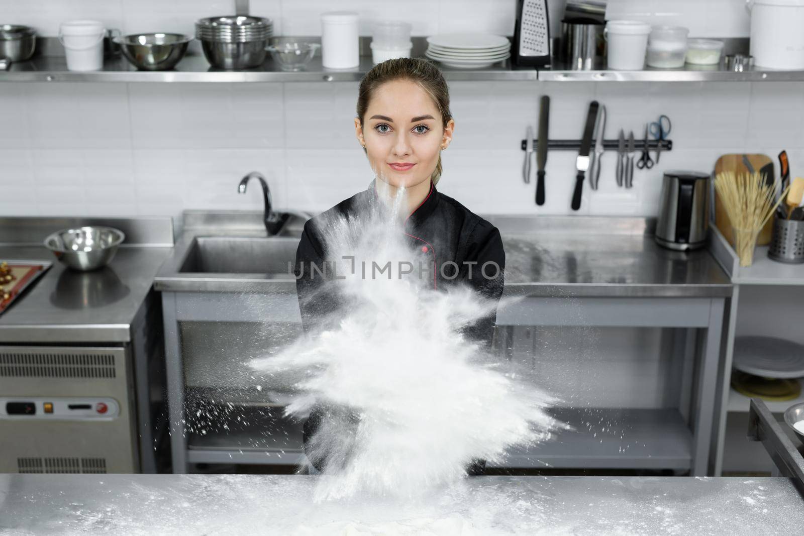 Pastry chef claps his hands and the flour is scattered all over the kitchen.