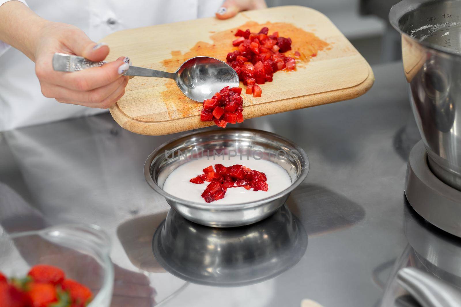 Pastry chef adds sliced strawberries to the cream by StudioPeace