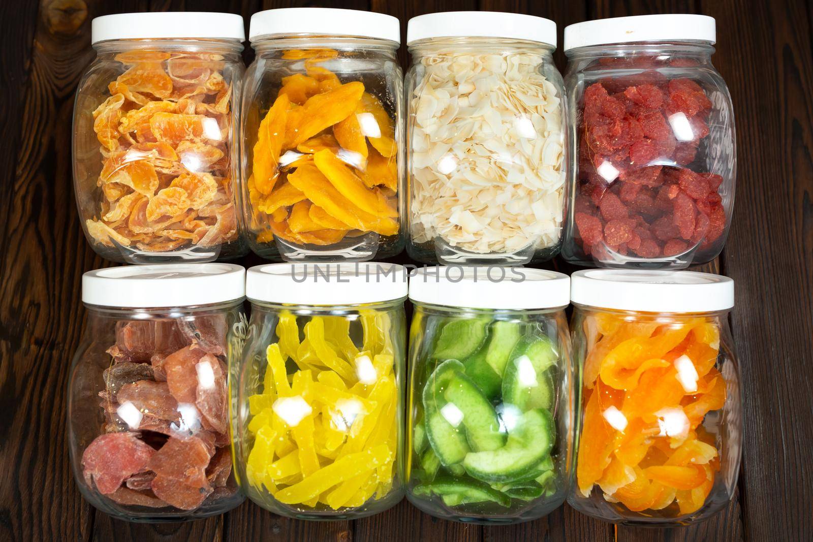 The concept of food, storage and nutrition - close-up of cans of dried fruit on a wooden background in a grocery store by StudioPeace