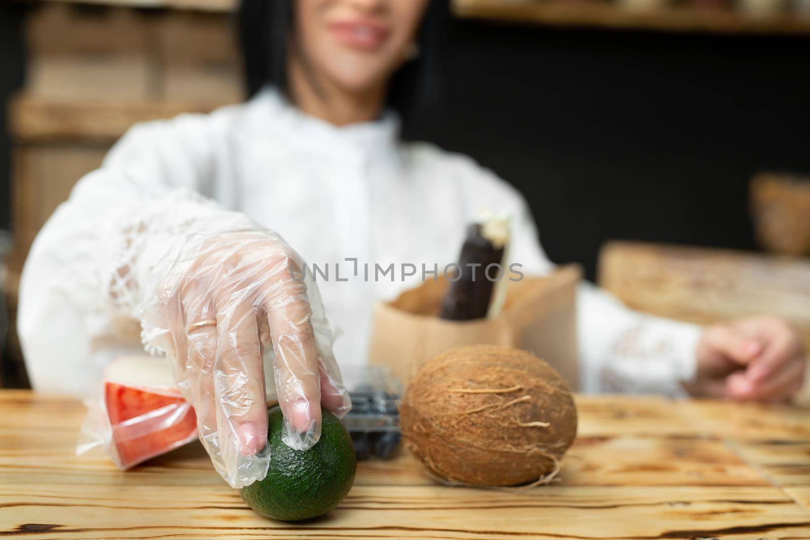 Saleswoman packs a shopping bag with goods in a health food store by StudioPeace