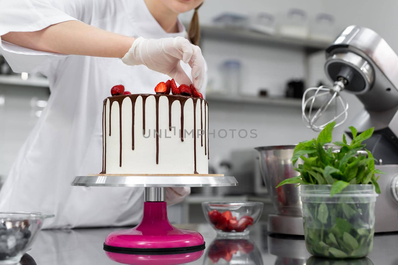 Pastry chef decorates the cake with chocolate streaks of strawberries by StudioPeace