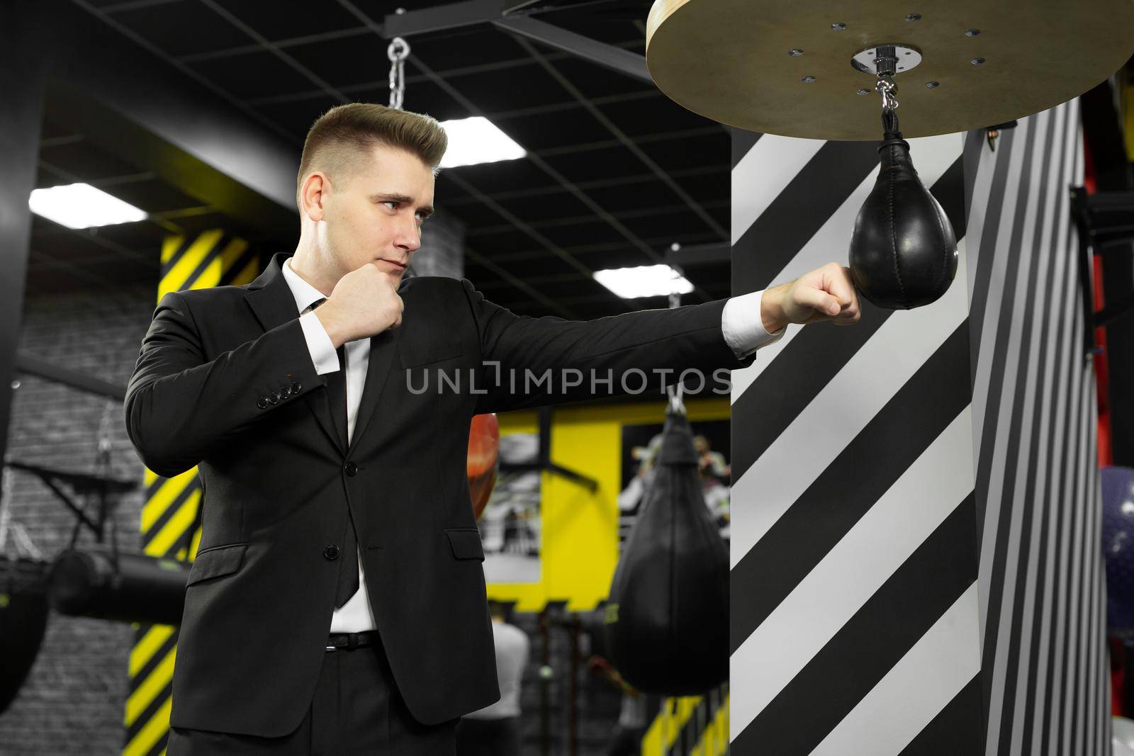 An evil businessman hits a punching bag in the gym. The concept of anger management by StudioPeace