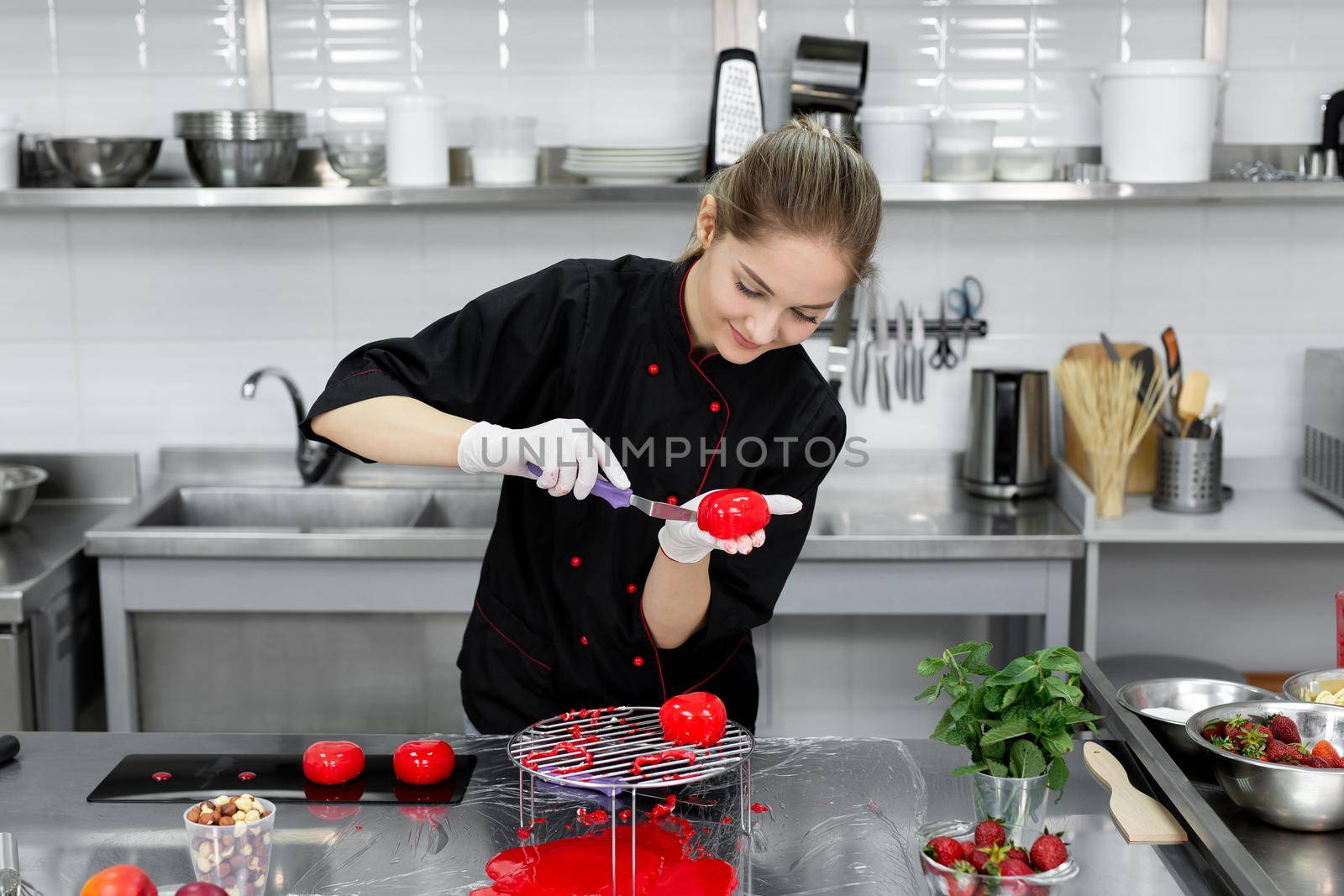 The pastry chef puts the mousse cake on the stand by StudioPeace