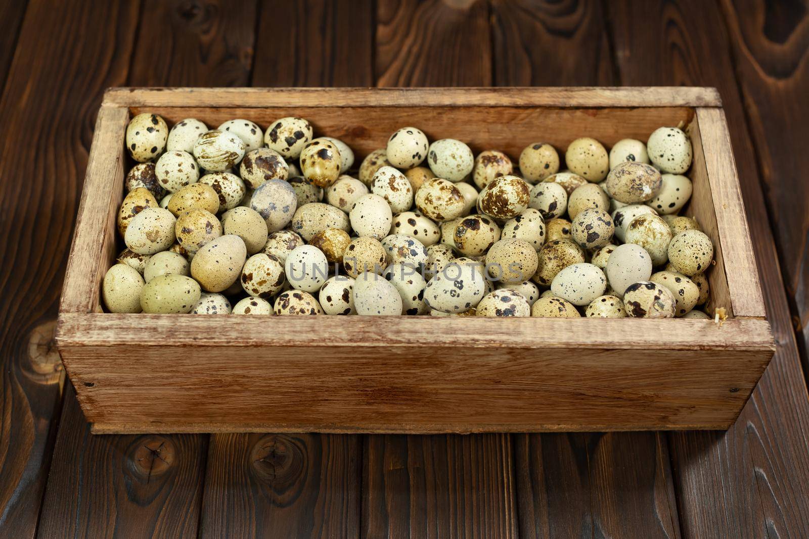 Lots of quail eggs in a wooden box on the background. by StudioPeace