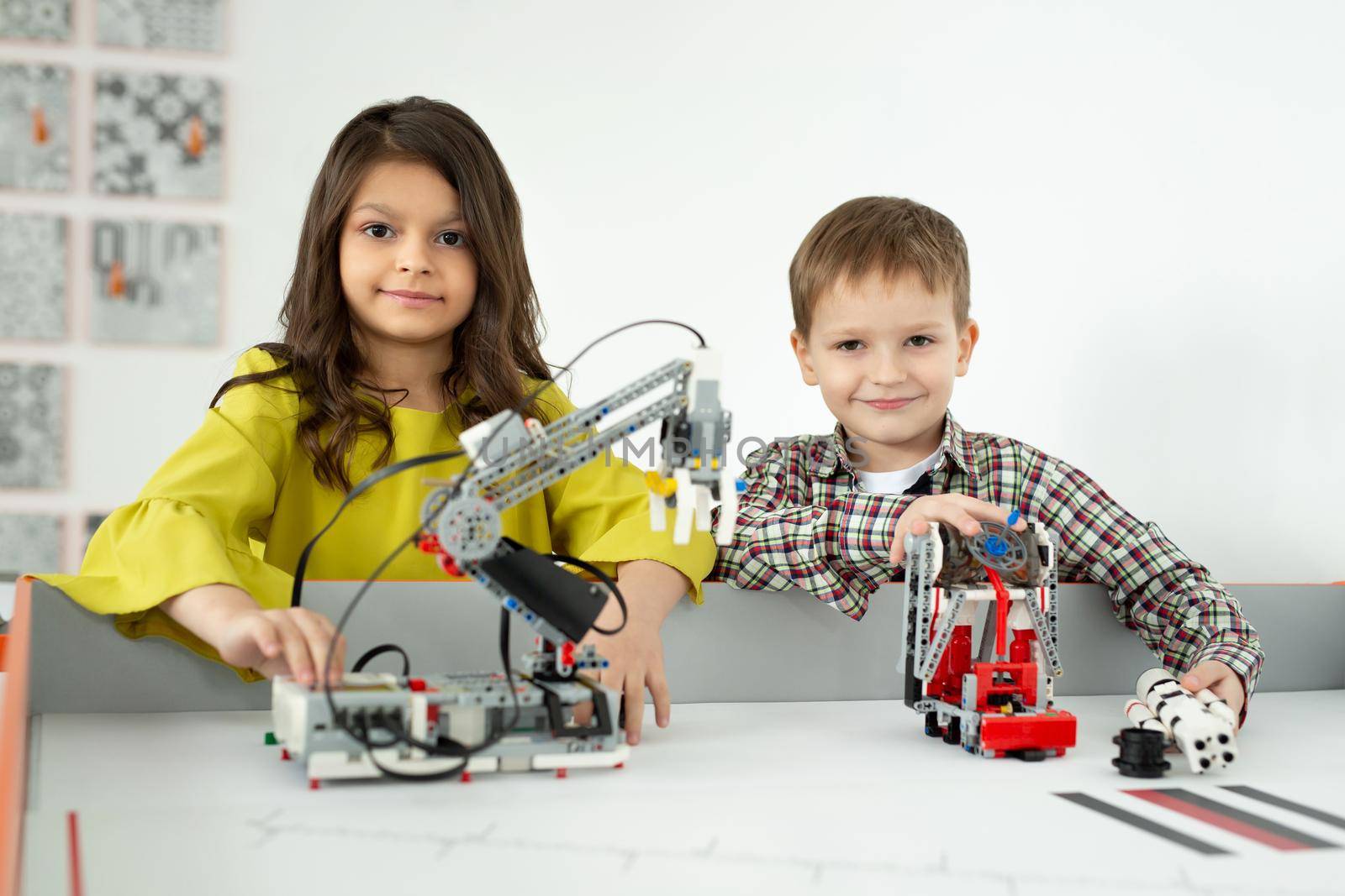 Boy and girl playing with a handmade robot. DIY robotics projects, fun and development, after school leisure.